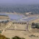 Aerial view of the Farakka Barrage on the Ganga River, showing the dam structure, river flow, and surrounding landscape.